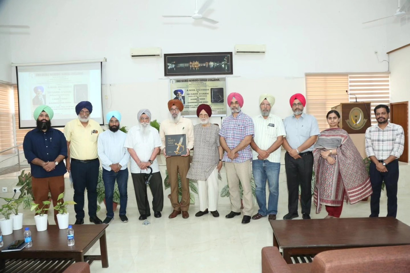 S. Gurbir Singh presents his book to the Principal, SGGS College, in the presence of management members and faculty.